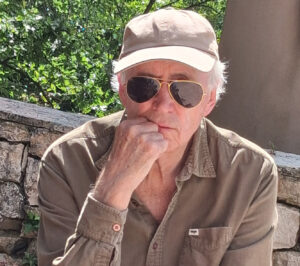 ein Mann mit Sonnenbrille und Cappy schaut in die Kamera.